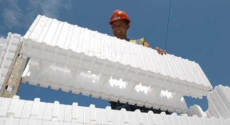 A builder with red hardhat building a wall with Wallform 313