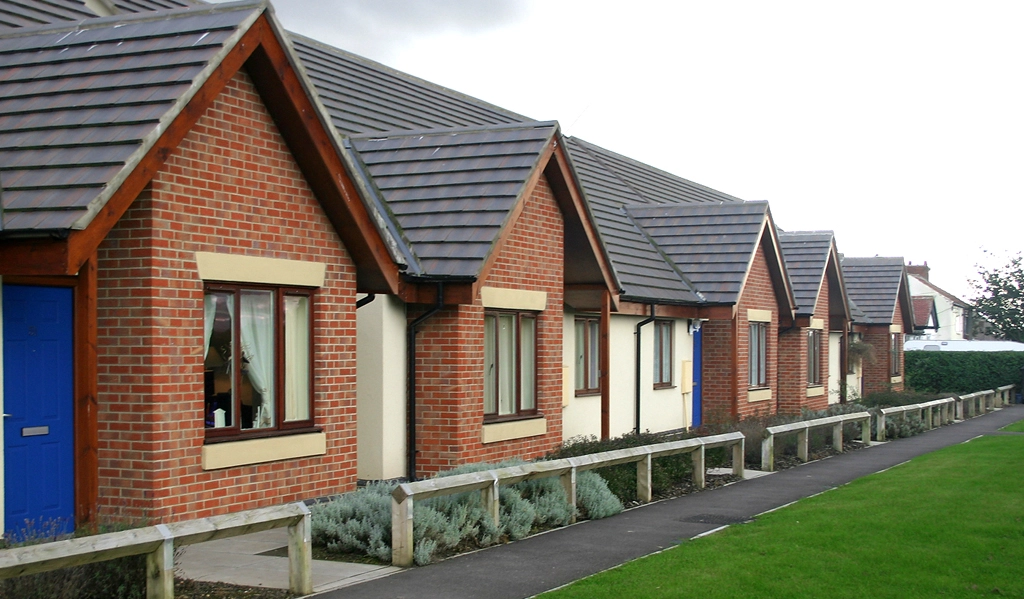 A row of terraced social housing with brick and render finishes