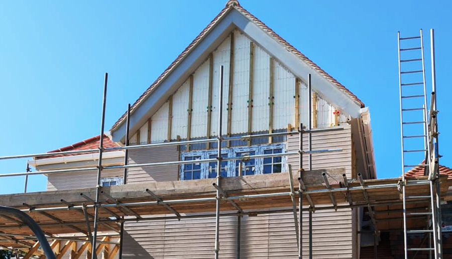 Brick slips being applied over a profiled background board